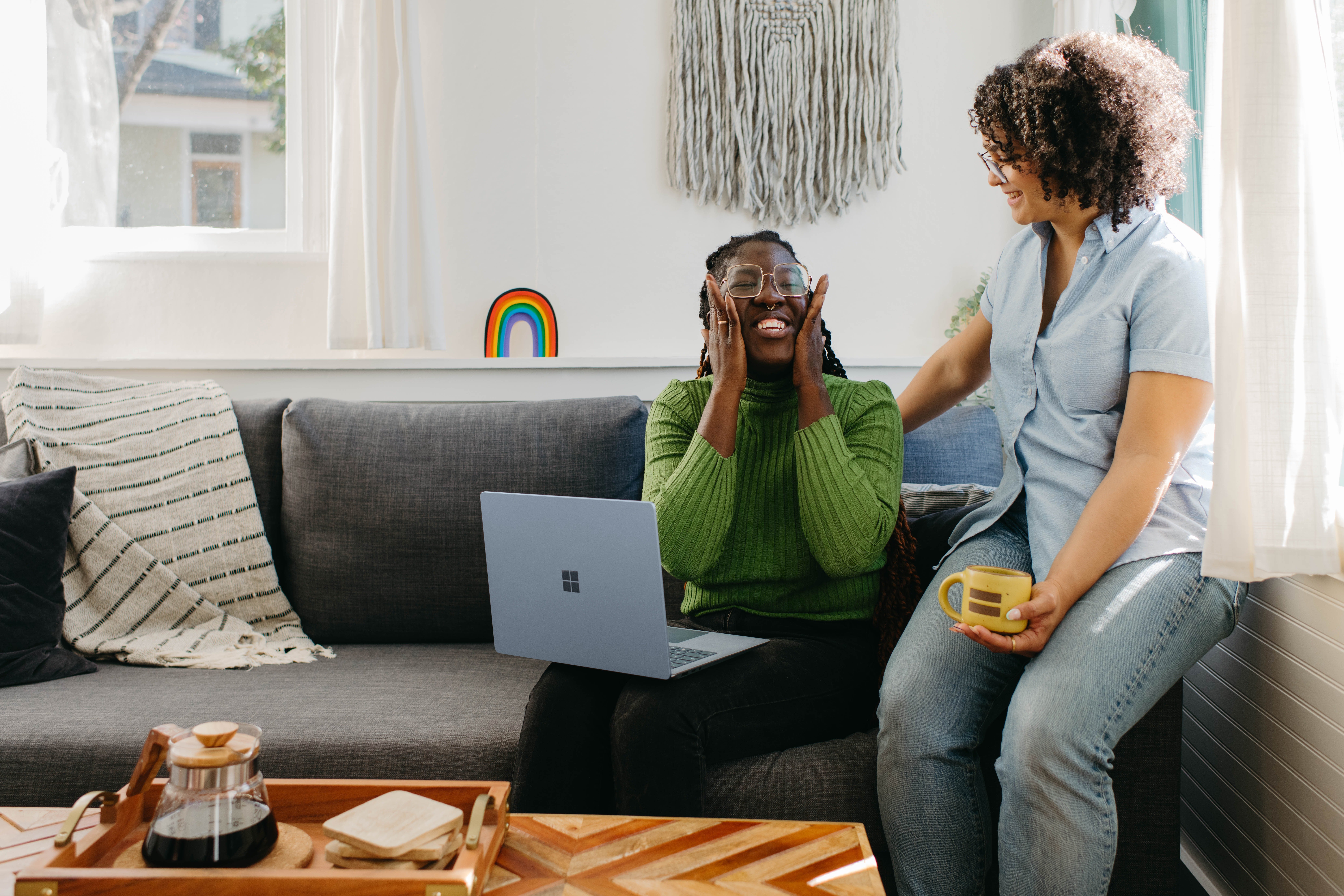two women smiling on a couch mental health in the workplace